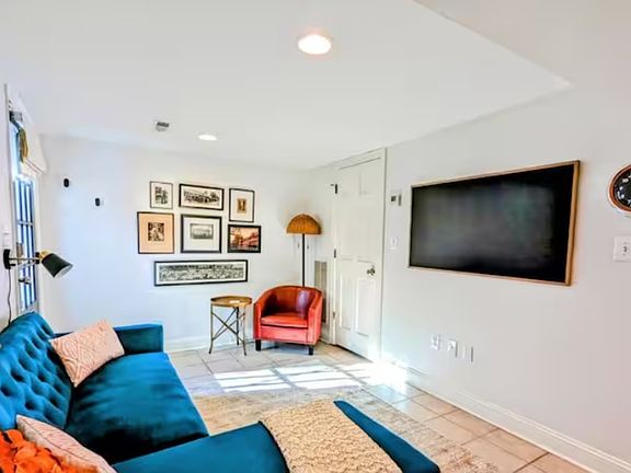 Furnished living room with Samsung Frame TV and pull-out chaise sofa.