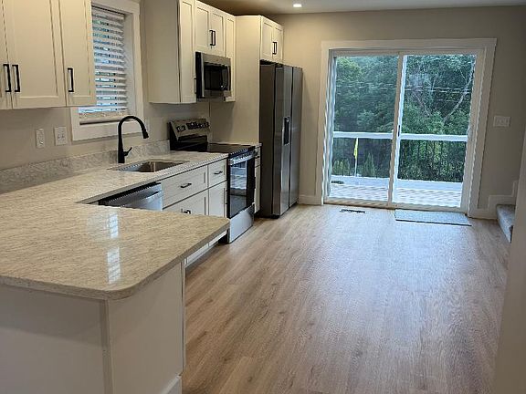 Spacious Kitchen with granite and dishwasher; access to the deck