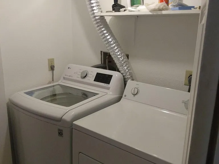 Basement laundry room complete with full size washer and dryer.