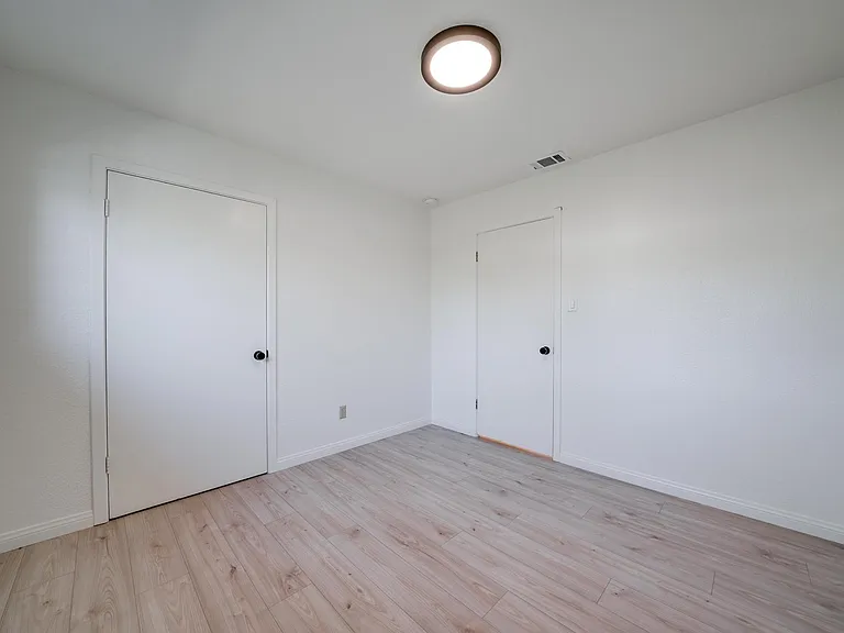 Middle bedroom. New paint, blinds, flooring, light fixtures. Closet door on the left.