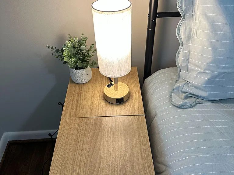 Touch-screen lamp with dimmed lighting options and bedside table with storage.