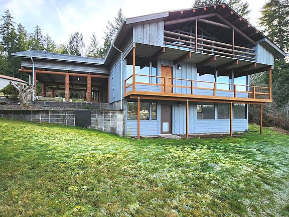 Back of the home with full length deck and a wall of windows.