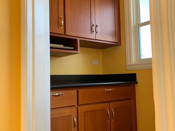 Pantry with custom cherry wood cabinets/ granite counter top- with door to small porch for BBQ