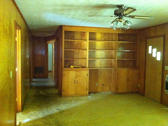 Spacious den with hallway leading to bedrooms