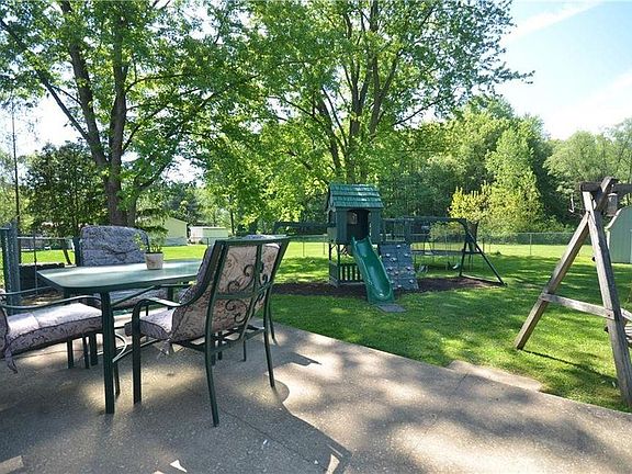 Beautiful fenced yard with porch, playset, swing and shed