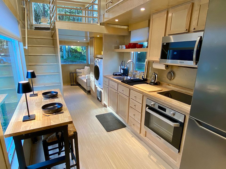 Light and airy kitchen space with open ceiling to feel very spacious. Induction stove, electric oven, fridge/freezer, microwave and storage cabinets. Washer/dryer combo.