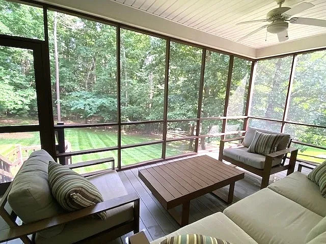 Back screened in deck, with stairs leading to back yard and two ceiling fans