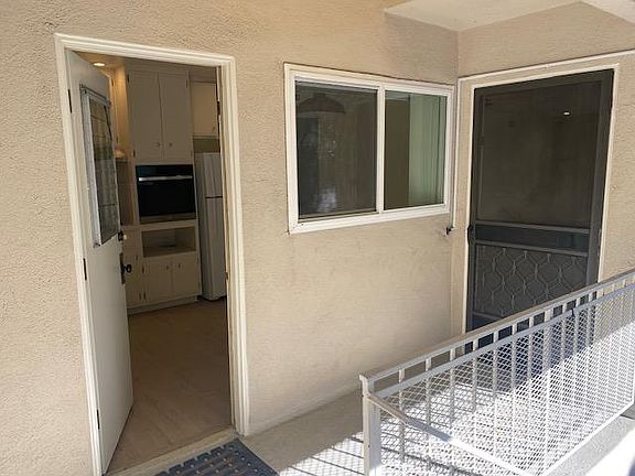 The door to the left opens up to the kitchen, the front door on the right opens up to the living room.