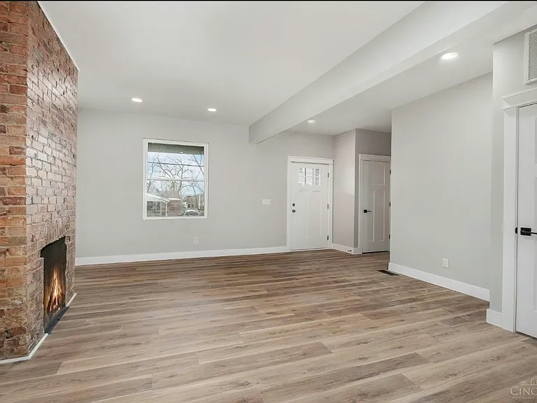 (1st floor) View of living room, basement door, and coat closet (next to entrance) from the kitchen