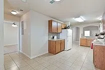The kitchen has extra space or additional furniture or a freezer