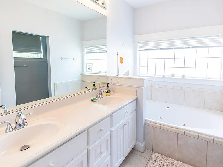 Master bathroom has a double vanity, a jetted tub and a glass enclosure shower.