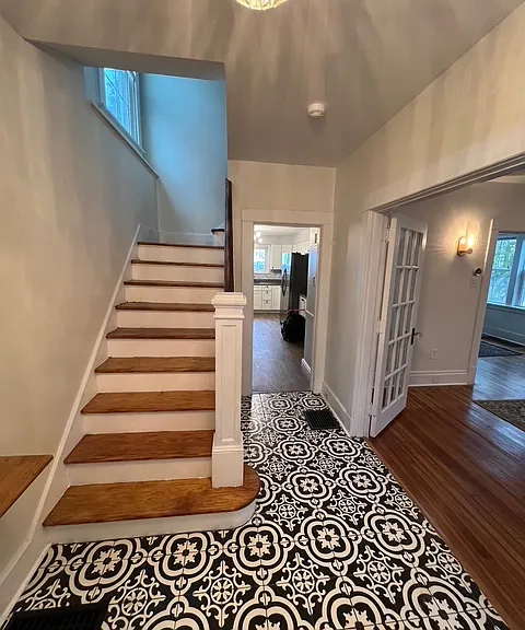 Entryway with brand new Italian tile and refinished hardwood stairs.