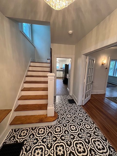 Entryway with brand new Italian tile and refinished hardwood stairs.