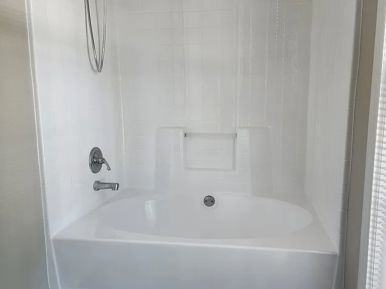 Ensute bath tub and shower surround which has been newly refurbished.