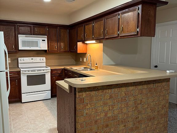 kitchen has lots of storage, sliding storage cart next to refrigerator and pantry