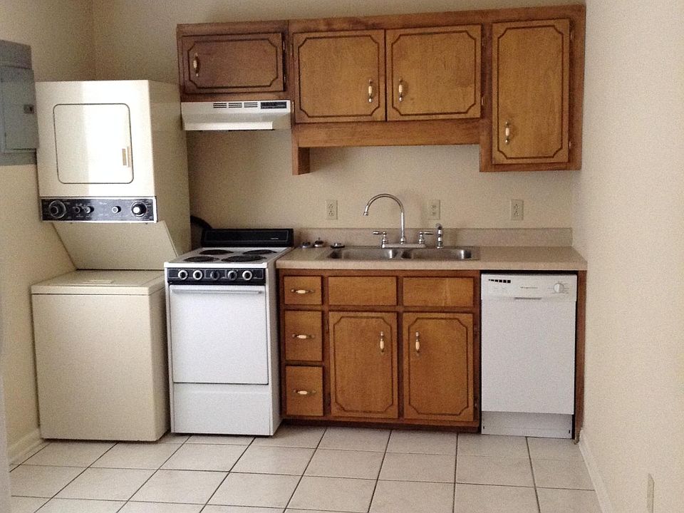 Kitchen, showing stove, dishwasher, stackable washer/dryer, cabinets.