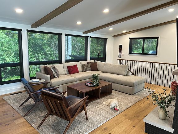 Family room from hallway, stairs to basement in back, Fireplace and TV to right.