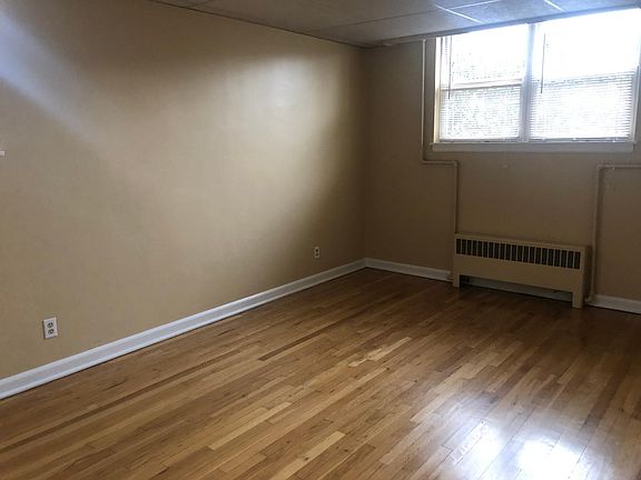 Bedroom with wood flooring, large double closet, and 3 windows.