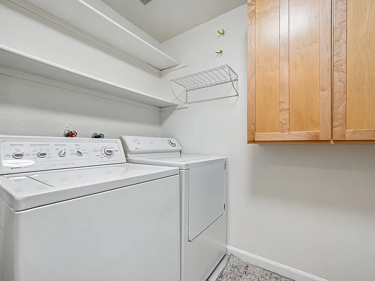 Laundry room with washer, dryer plenty of storage and new tile flooring.