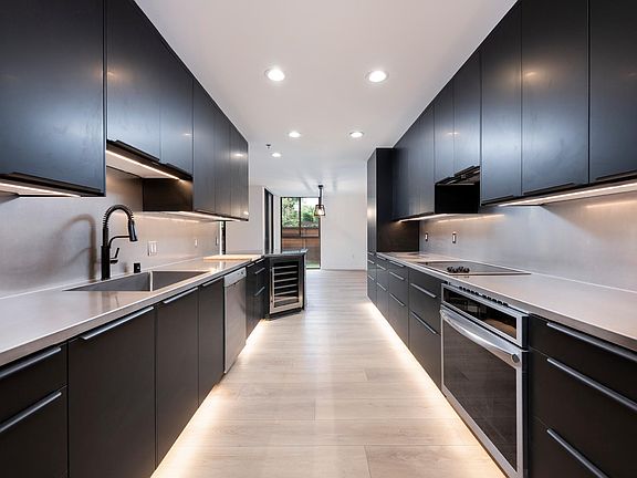Kitchen facing dining area and wine refrigerator.