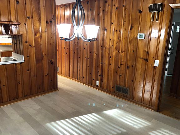 Dining room and kitchen feature solid, knotty-pine wood paneling and waterproof, luxury vinyl plank flooring.