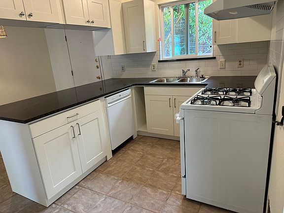 U shaped kitchen looks into morning light.