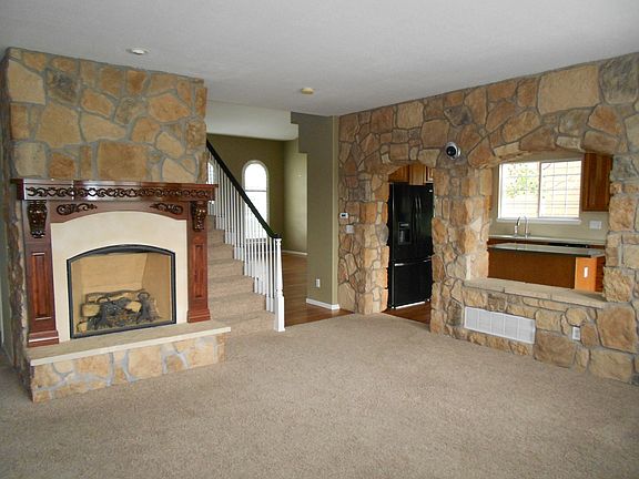 Family room opens to kitchen via beautiful stone wall.