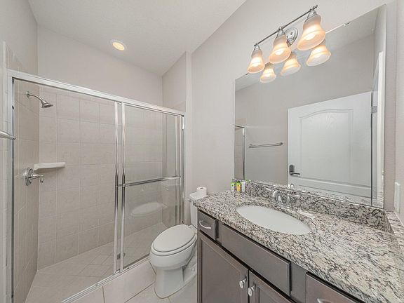 Enjoy the comfort and privacy of your own modern bathroom featuring a spacious glass-enclosed shower, granite vanity, and hot