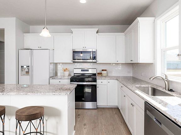 The timeless, bright white Kitchen cabinets provide plenty of storage space.