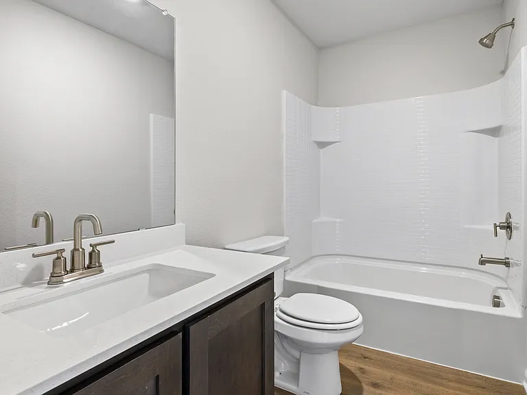 The secondary bathroom has a sprawling vanity and shower-tub combo.