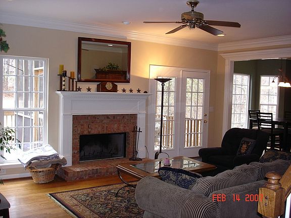 Den features woodburning fireplace, hardwoods, and lots of windows