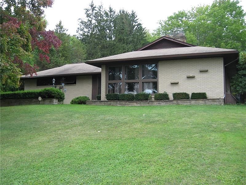 UNIQUE, CONTEMPORARY HOME IS SET BACK ON NEARLY AN ACRE LOT THAT BORDERS THE GOLF COURSE WITH A PRIVATE SETTING AND EASY ACCESS 
