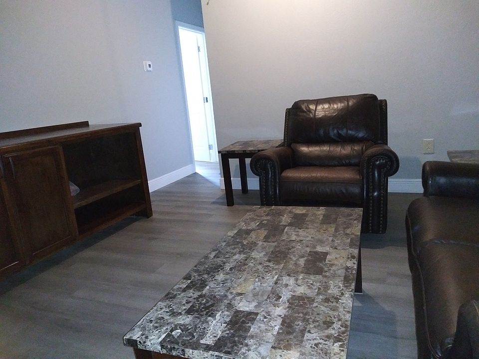 Living room with leather sofas and entertainment center.