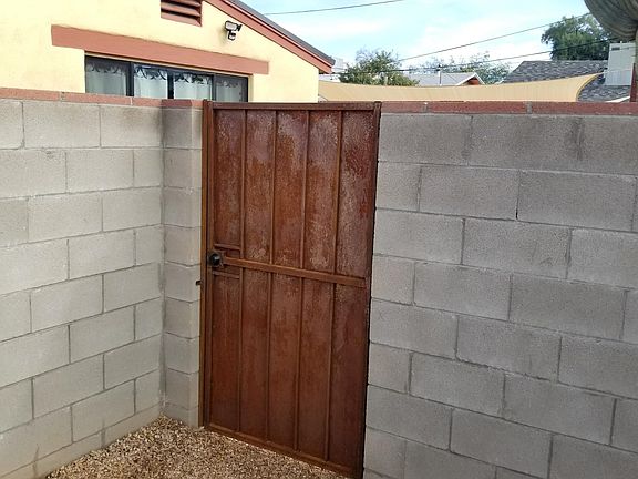 Keyed entry metal security gate. Six foot block wall.