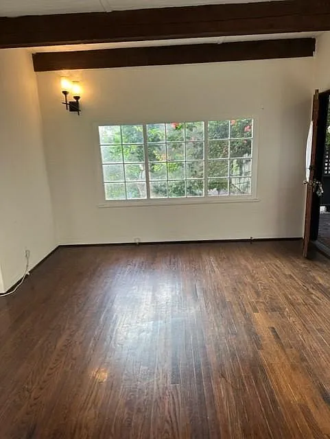 Opposite end of living room, has large picture window facing nature.
