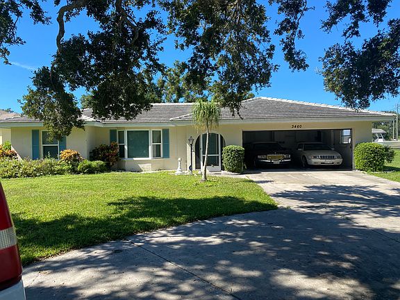 Front of house showing the garage with 2 Cadillacs , to show how large the garage is