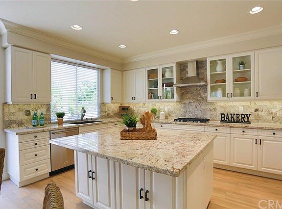 A closer look at the kitchen showing the extended island counter top, white cabinets etc.