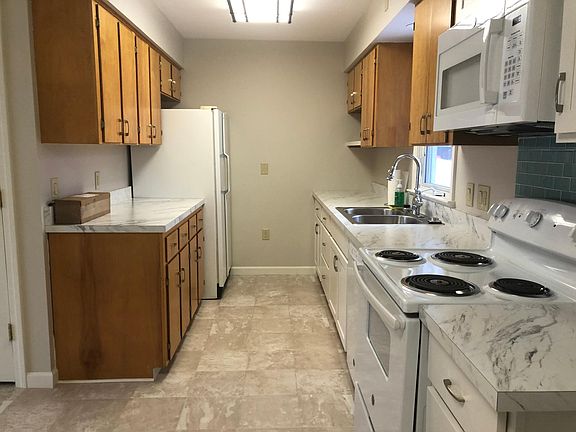Galley kitchen with lots of cabinets and works surfaces.