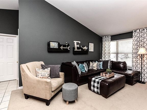 Vaulted great room with neutral carpet is stylish and comfortable