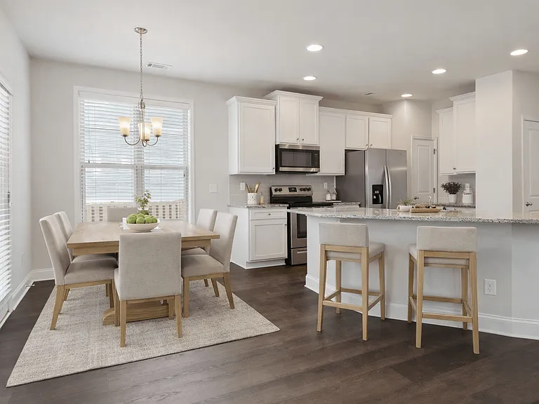 A view of the spacious kitchen, dining area, and stainless steel appliances