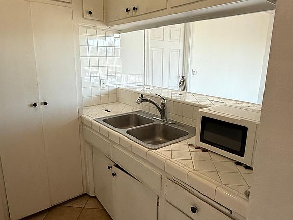 kitchen with microwave, stove, and ample storage and open to the rest of the apartment