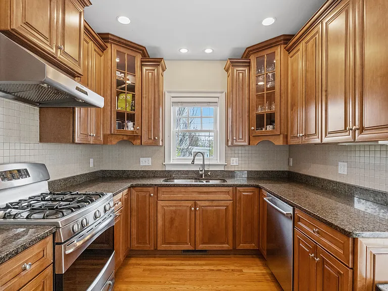 High-end kitchen with granite countertops, stainless steel appliances, and gas cooking.