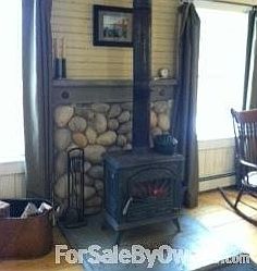 River rock wall behind stove
						:
						Hand made concrete base underneath. Glass door allows you to see the flames