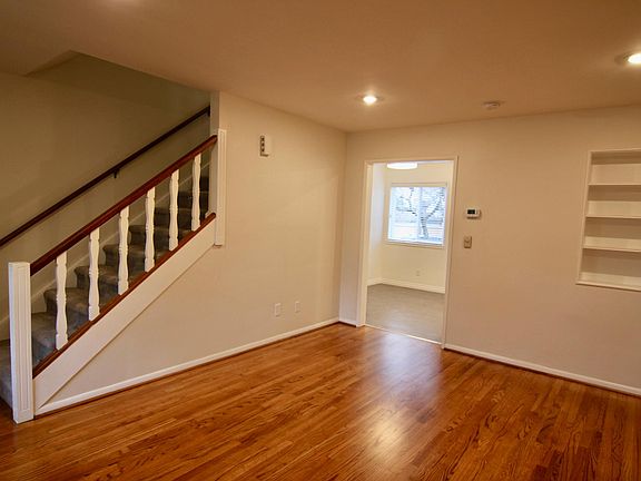 View of living room from front door to kitchen entry. Stairway to 2nd floor.