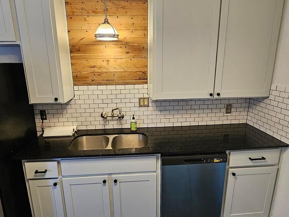 New cabinet fronts and dishwasher. Granite countertops and subway tile backsplash.