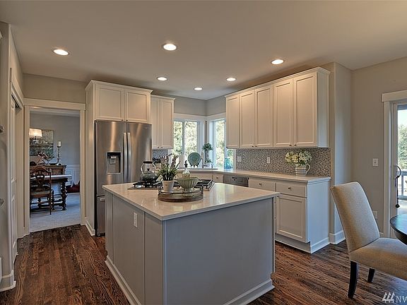 Stunning updated white kitchen with light gray island, new appliances, backsplash and quartz countertops.
