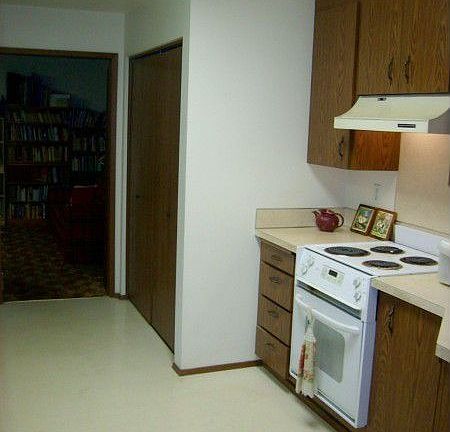 Plenty of pantry and easy-to-maneuver linolium flooring are featured in the kitchen which leads to t