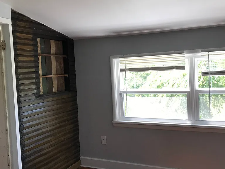 Bedroom 1 with exposed shiplap and custom decorative shelves. 2 closets!!
