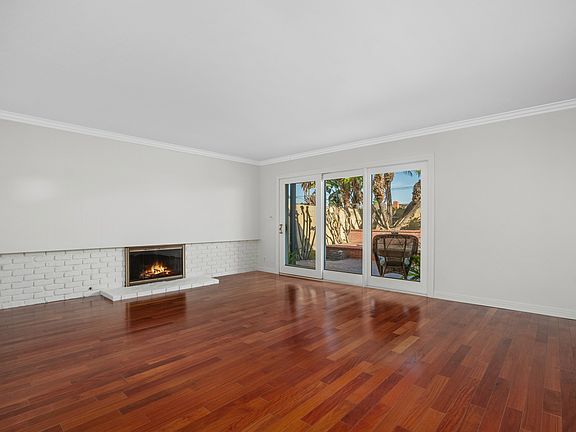 Living Room with white brick fireplace and French Doors leading to the backyard patio area