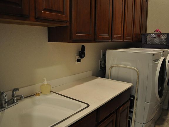 laundry room with high efficiency washer and dryer. sink and counter too!